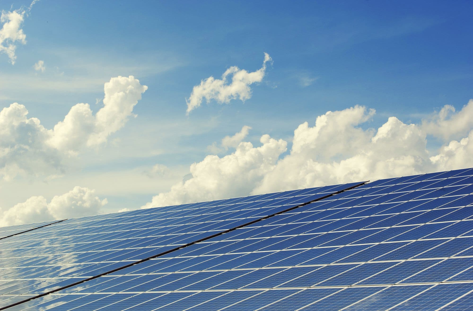 Solar panels reflecting a blue sky