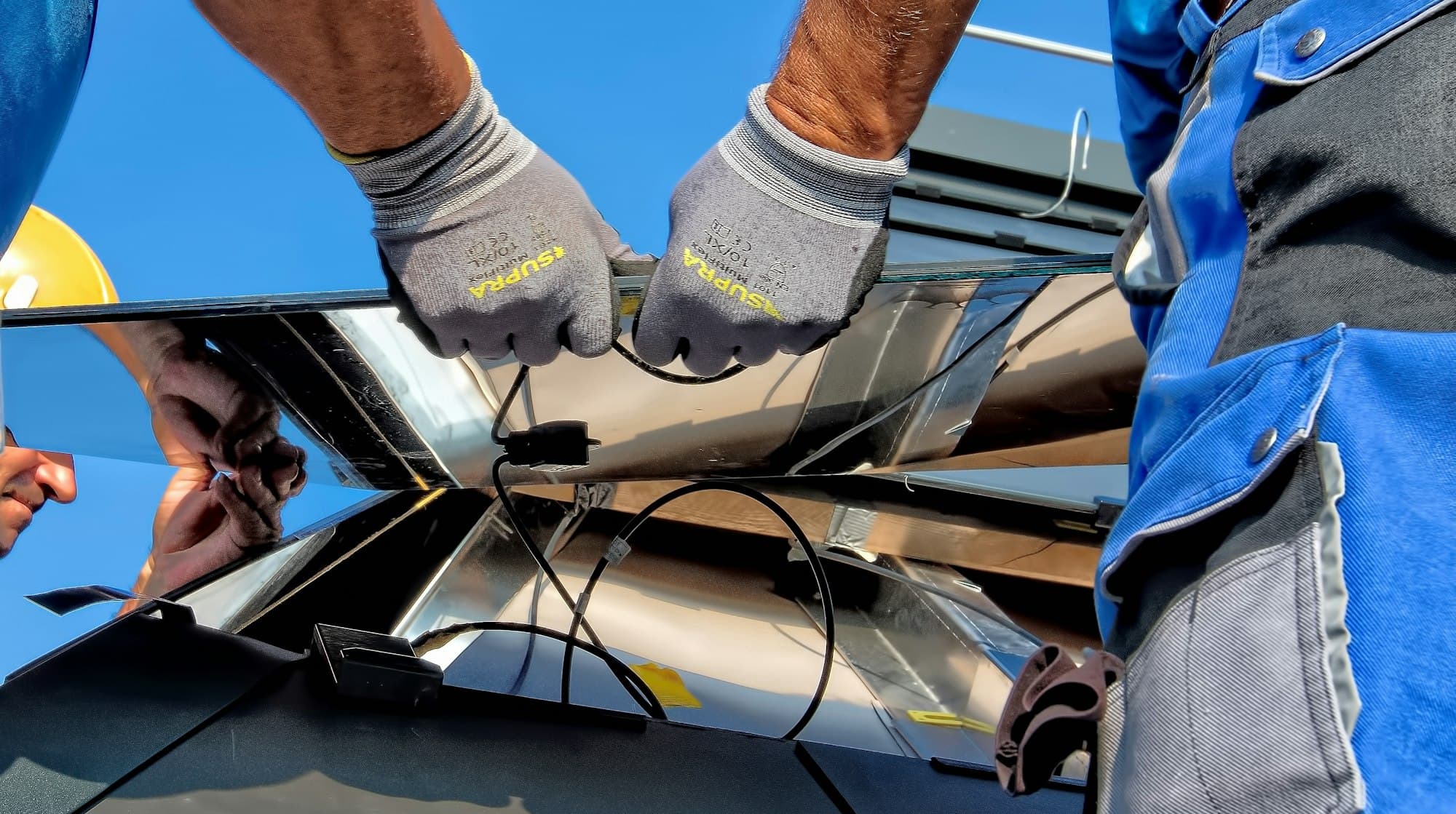 Installers lifting a solar panel into place